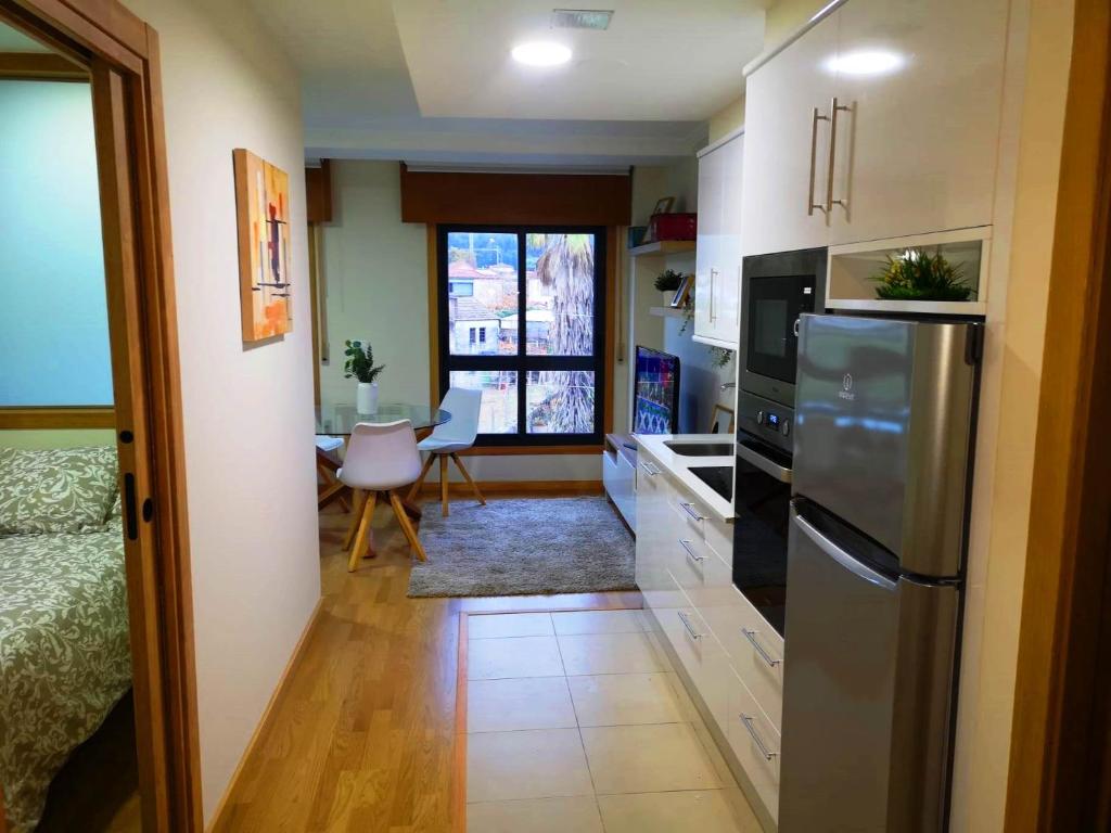 a kitchen with a refrigerator and a dining room at Apartamento A Cabana II in Porriño