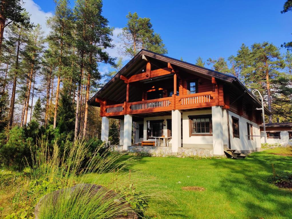 a wooden house with a balcony on a yard at Kolin Runo in Yläkoli