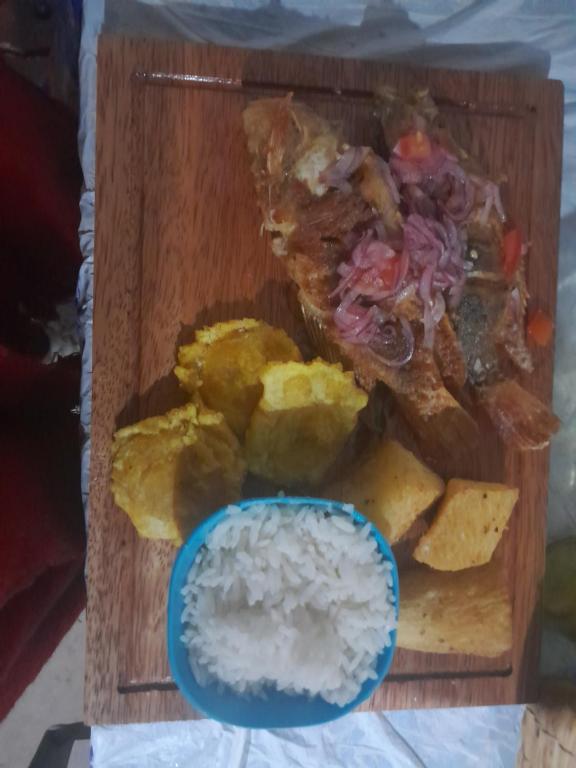 un vassoio di legno con riso e un piatto di cibo di Hostería Quinta San Antonio a Nanegal