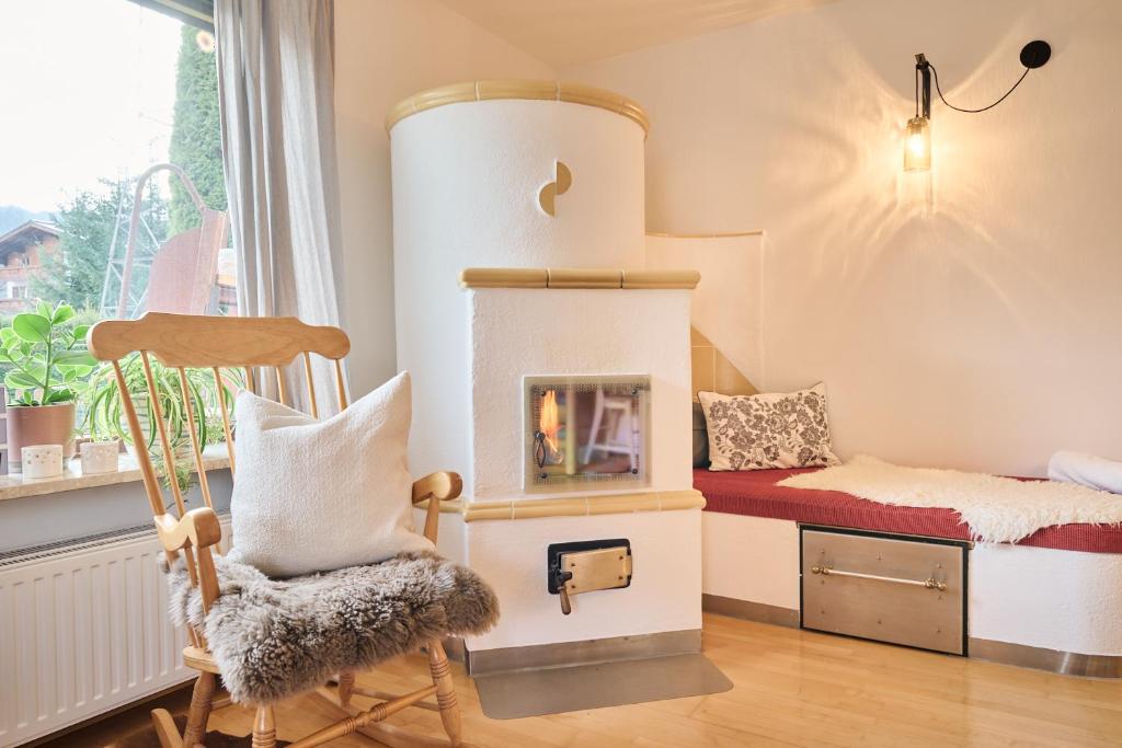 a room with a fireplace and a chair and a bed at Bungalow Nr. 33 in Altenmarkt im Pongau