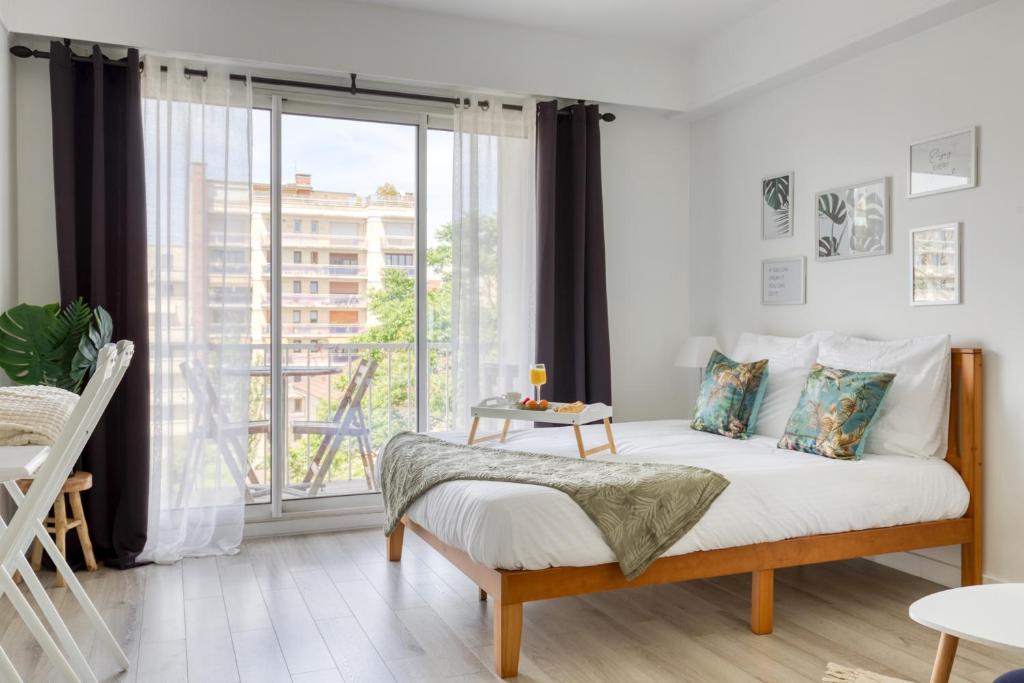 a bedroom with a bed and a large window at Zzzen aux portes de Paris avec Parking et Netflix in Vincennes