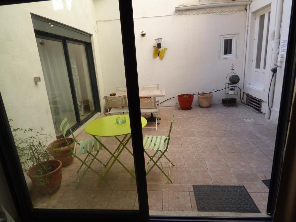 a view of a patio with a table and chairs at "Le Patio"-Meublé de Tourisme 3 étoiles -Résidence "Les Logis de Béziers"-Garage optionnel-Cœur de ville-Plages à 16km ! in Béziers