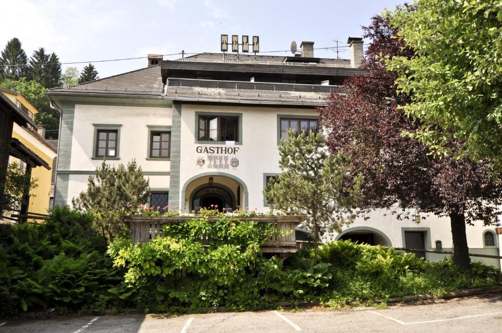 an old white building with a sign on it at Gasthof Tell in Paternion