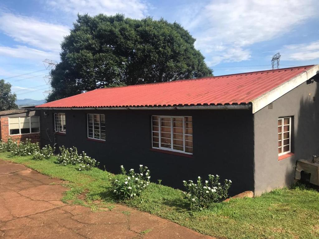 una casa en blanco y negro con techo rojo en Vukaphi Farm, en Cleland