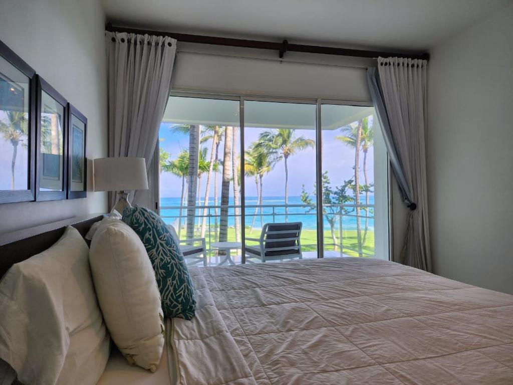 a bedroom with a bed with a view of the ocean at SEAWINDS CABARETE Front beach Condo in Cabarete