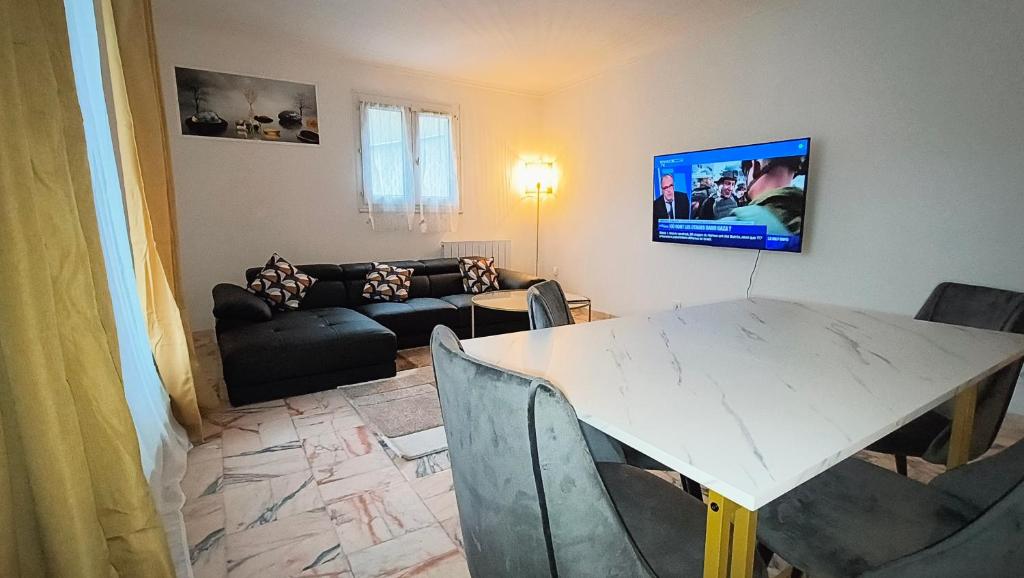 a living room with a table and a tv on the wall at Dujardin Home in Montmagny