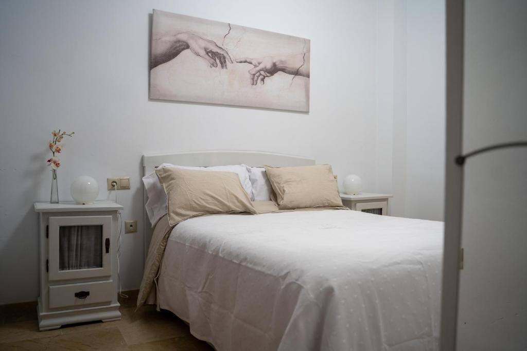 1 dormitorio con 1 cama y una pintura en la pared en Bonito piso en San Ildefonso - Centro, en Jaén