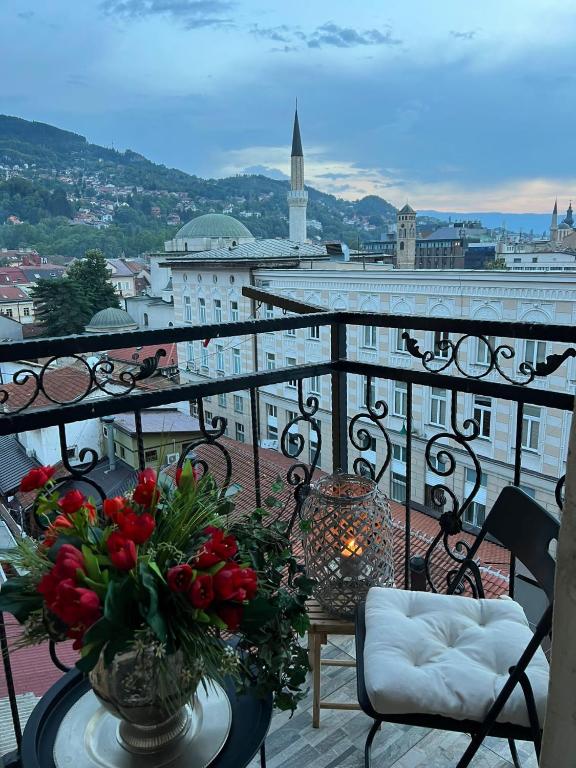a balcony with a table with flowers on it at Apartment Leyla in Sarajevo