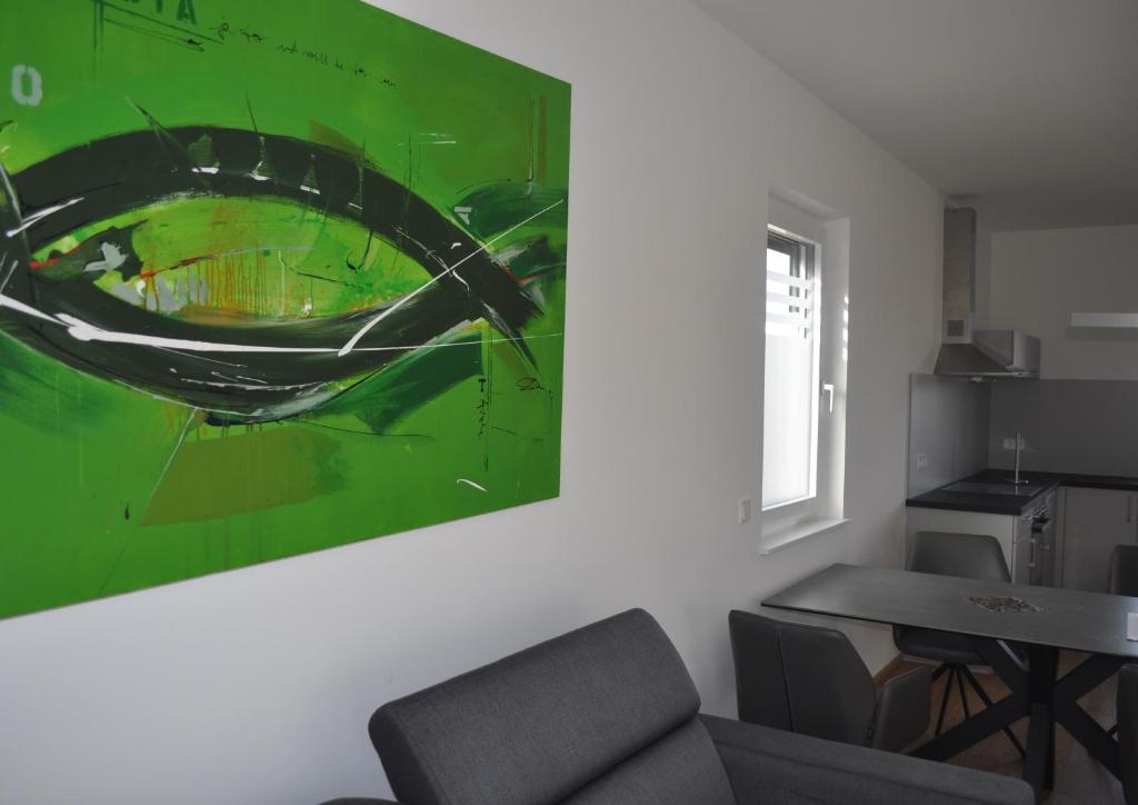 ein Esszimmer mit einem grünen Gemälde an der Wand in der Unterkunft Sonnige Neubauwohnung - Gratwein in Kugelberg