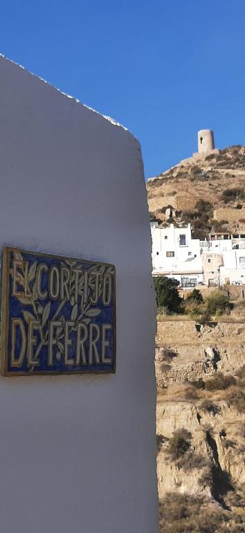 una señal en el costado de una pared en Cortijo Ferre, a los pies del castillo la Atalaya de Nijar en Níjar