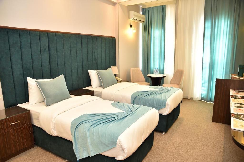 En eller flere senge i et værelse på Karat Inn Boutique Hotel