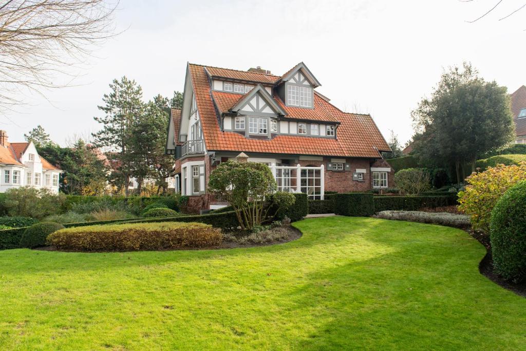 ein Haus mit grünem Rasen davor in der Unterkunft Sunbeam family house at seaside in Knokke-Heist