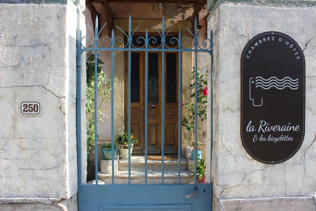 an entrance to a door with a sign on it at La Riveraine et les bicyclettes in Saint-Sauveur-de-Montagut