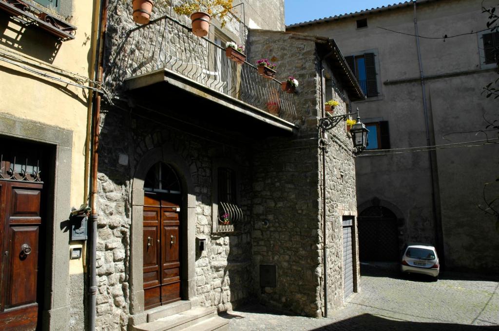 an old stone building with a balcony and a door at Antica residenza La Rocca in Montefiascone