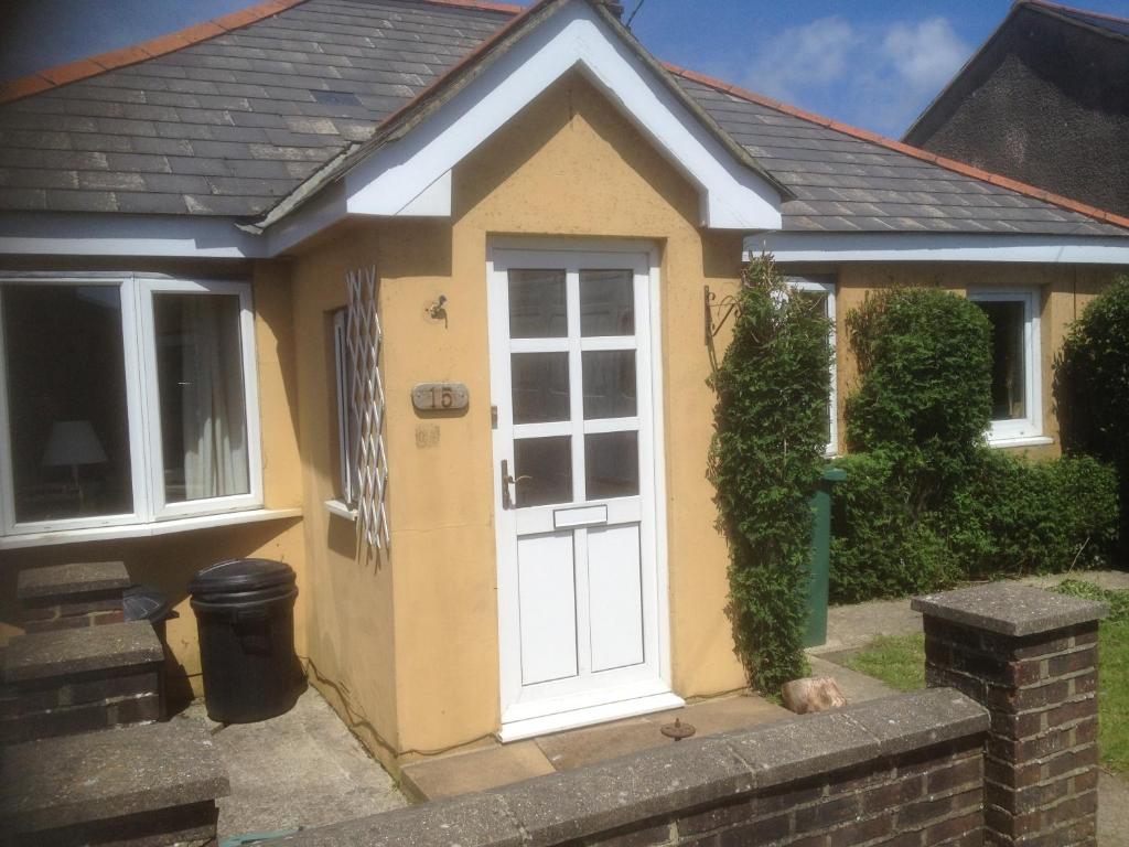 mały żółty dom z białymi drzwiami w obiekcie Beech Road w mieście Newport