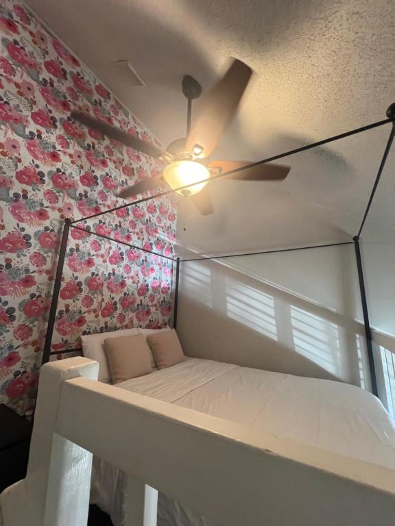 a bed in a room with a ceiling fan at Poppy Loft in Raleigh