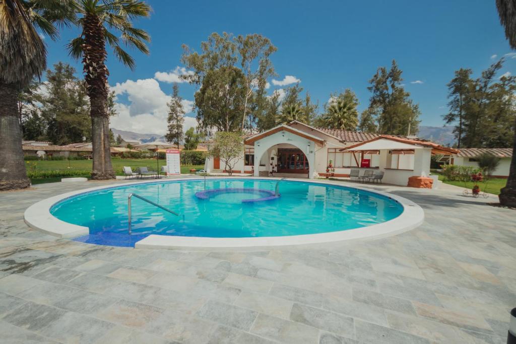 een zwembad in een tuin met een huis bij HOTEL & SPA LAGUNA SECA in Los Baños del Inca