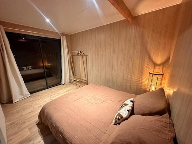a bedroom with a bed and a large window at HAVRE DE PAIX LES PIEDS DANS L&#39;EAU in Istres