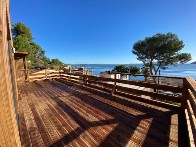 a wooden deck with a view of the ocean at HAVRE DE PAIX LES PIEDS DANS L&#39;EAU in Istres