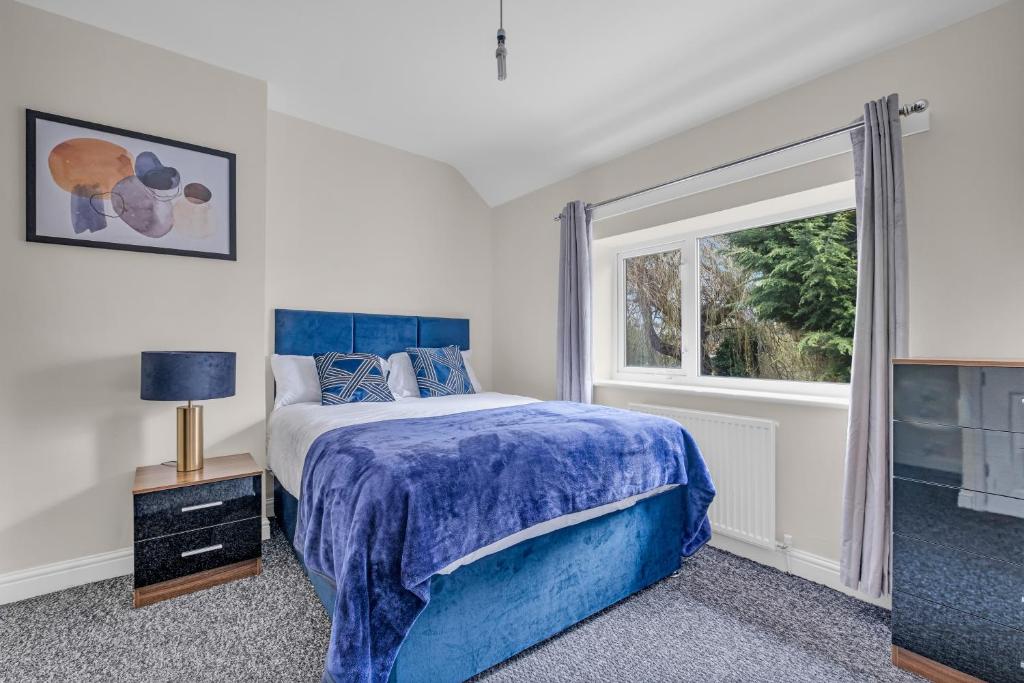 a bedroom with a blue bed and a window at Doncaster DN8 Elegant 3 Bedrooms Travellers Contractors Haven Free Parking in Thorne