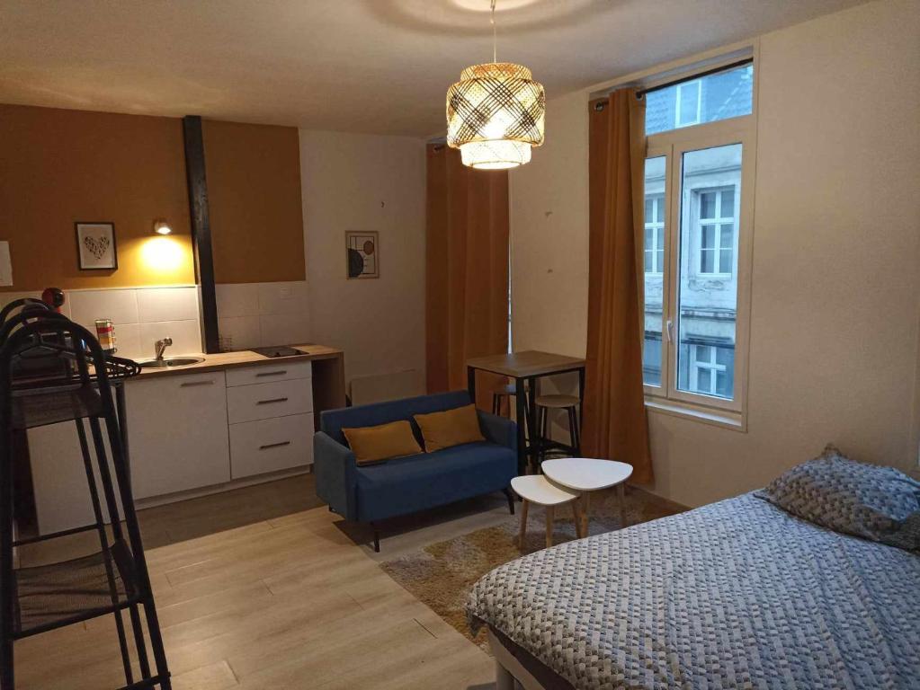 um quarto com uma cama e uma cozinha com uma mesa em Deguise 9 em Valenciennes