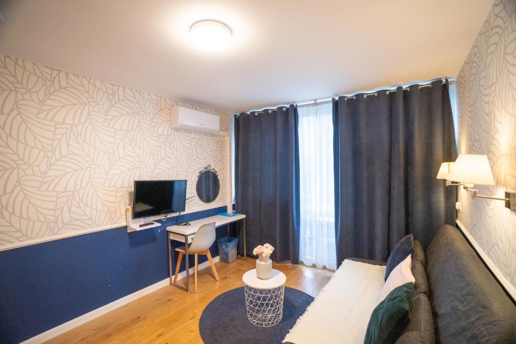 Televízia a/alebo spoločenská miestnosť v ubytovaní Apartament Hotel Grzybowska 9