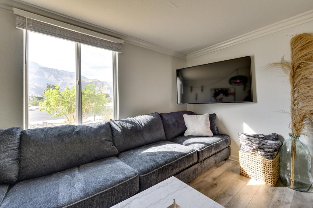 a grey couch in a living room with a window at Private Patio, Community Perks Palm Springs Condo in Palm Springs