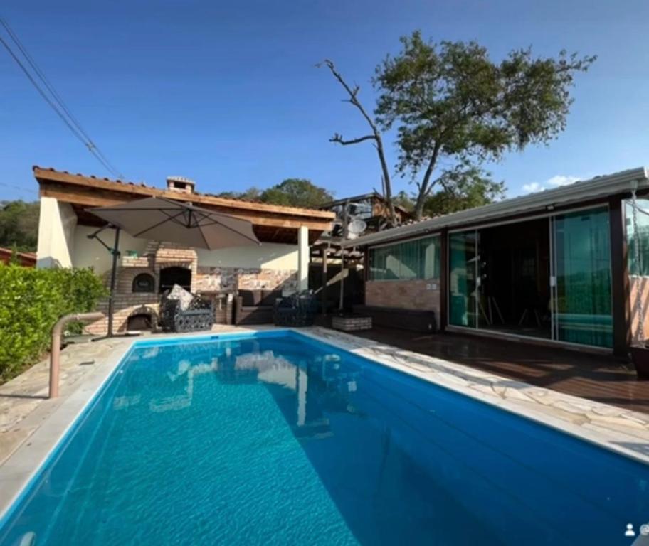 uma piscina azul em frente a uma casa em Chácara chalé com piscina 30min de SP em Itu