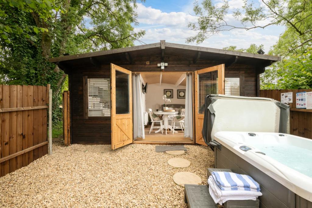 a small shed with a tub and a table at Hazel - Connect to the Nature in the Hot tub in Blandford Forum