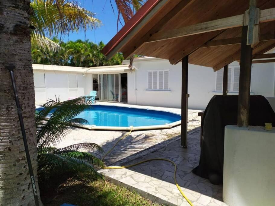 a swimming pool in the backyard of a house at À 15’ de Poe Belle Villa in Bourail