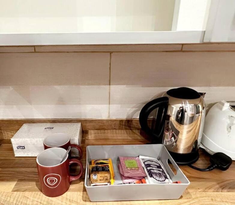 a box on a counter with cups and a tea kettle at Cosy Quiet Single Studio in Merton