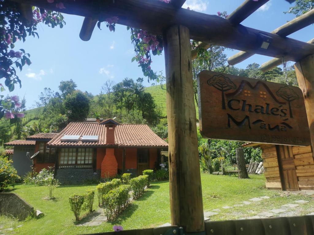a sign in front of a small house at Chalé Mauá Conforto e Arte in Visconde De Maua