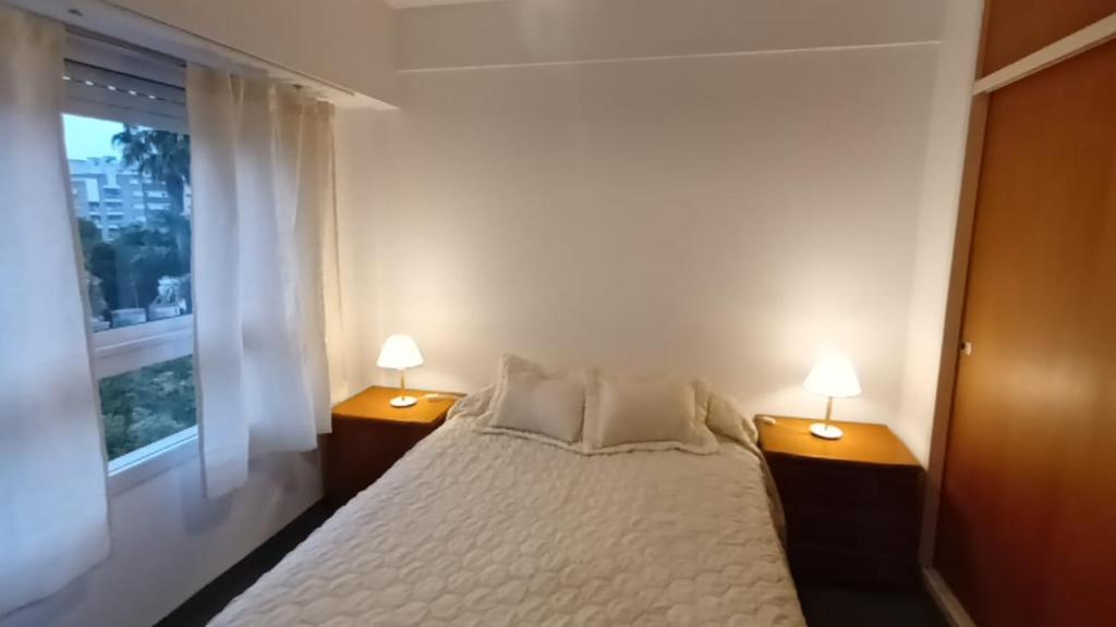 - une chambre avec un lit blanc et 2 lampes dans l'établissement DEPTO 2 Y 62 CON COCHERA PROPIA, à La Plata