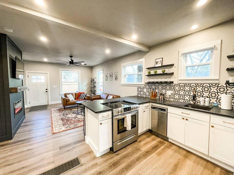 uma cozinha com armários brancos e uma sala de estar em Designer Retreat / Central loc/walk to brewery/café em Colorado Springs