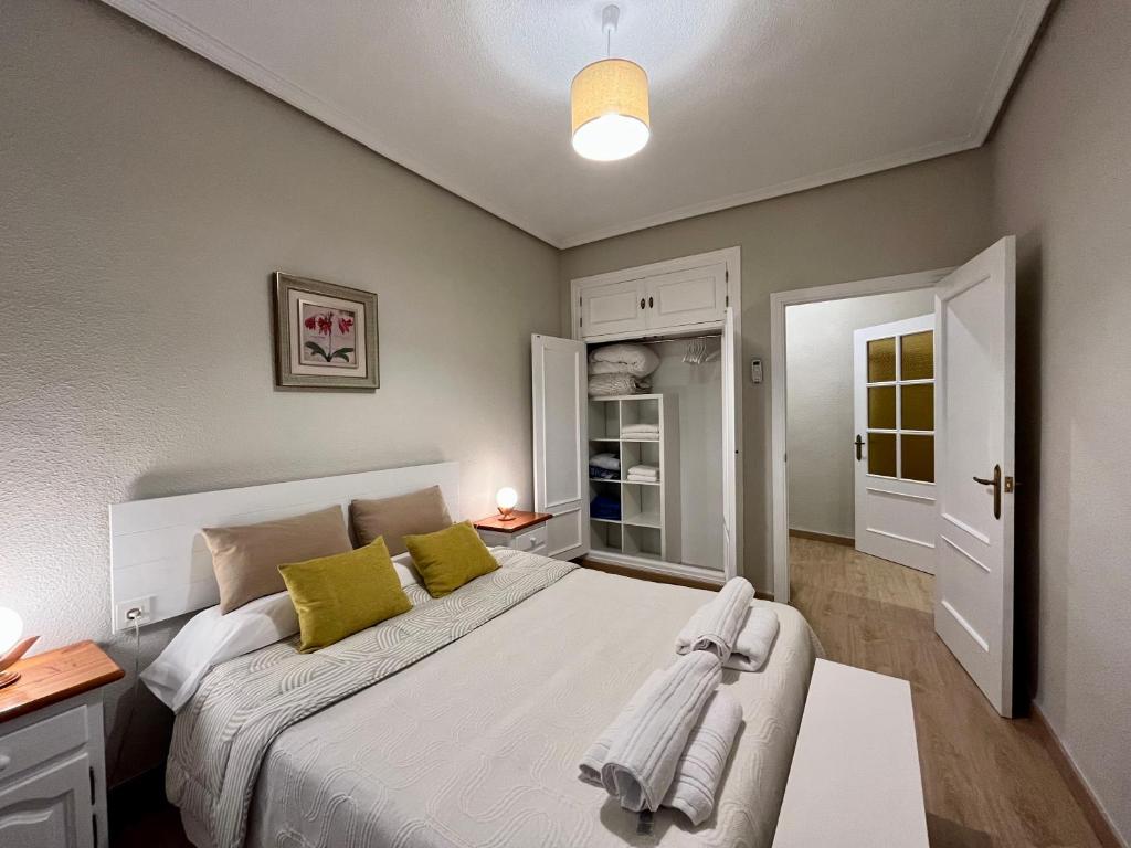 a bedroom with a large white bed with yellow pillows at Apartamento Castilla 30 - Parking Publico Gratuito in Toledo