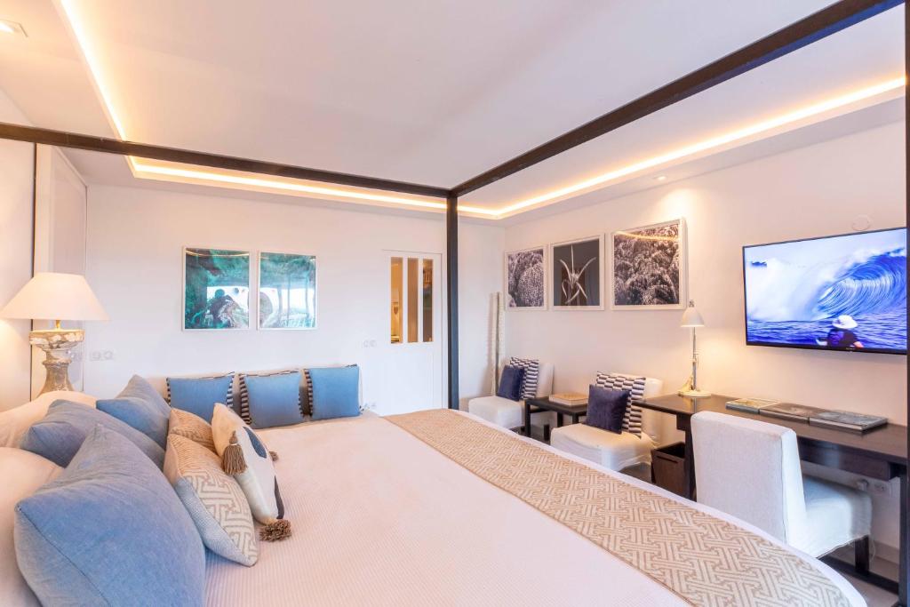 Anse des CayesにあるArt et mer suite Saint barthのベッドルーム(大型ベッド1台、青いソファ付)