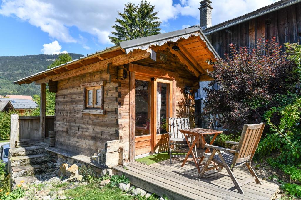 a log cabin with a table and chairs on a deck at Mazot De La Marcelline in Saint-Gervais-les-Bains