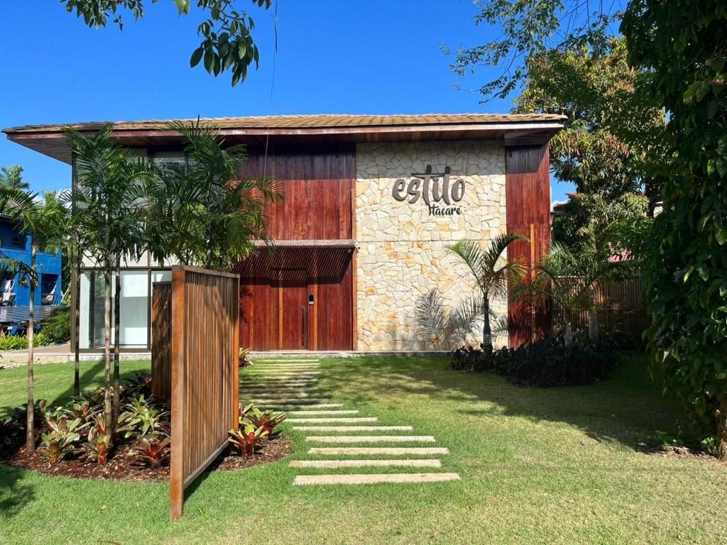 a building with a red door and a grass yard at Estilo Itacaré best location in Itacaré