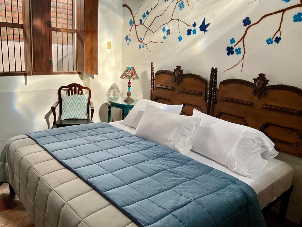 a bedroom with a bed with a blue comforter at CASA SINNING-año1637 in Mompos