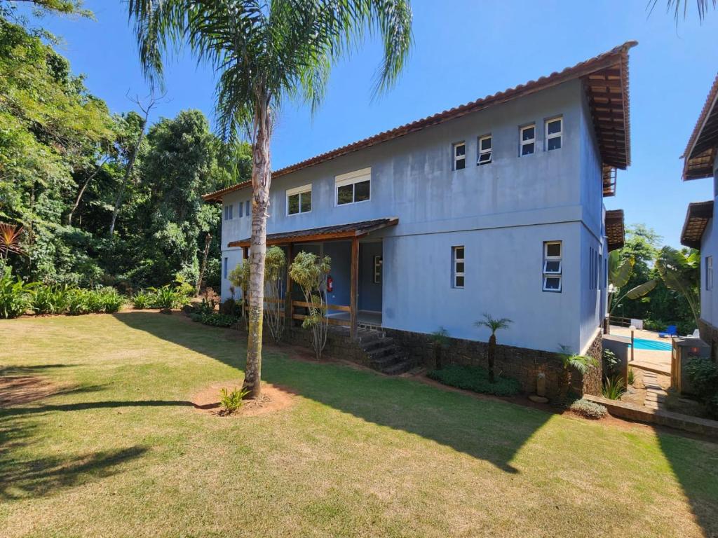 una casa con una palmera en el patio en Hospedaria Ilhabela - Casa Maritacas, en Ilhabela