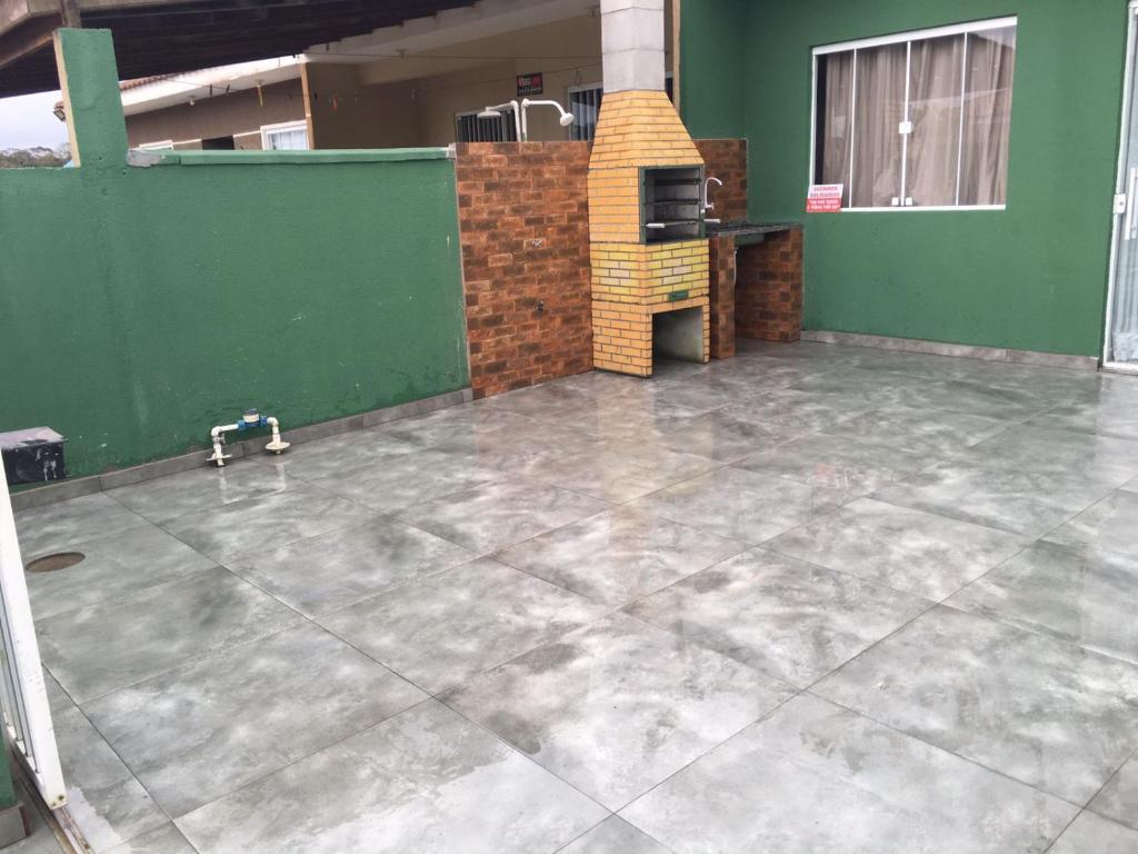 an empty room with a concrete floor and a stove at Casa Arejada 300mts do mar in Guaratuba