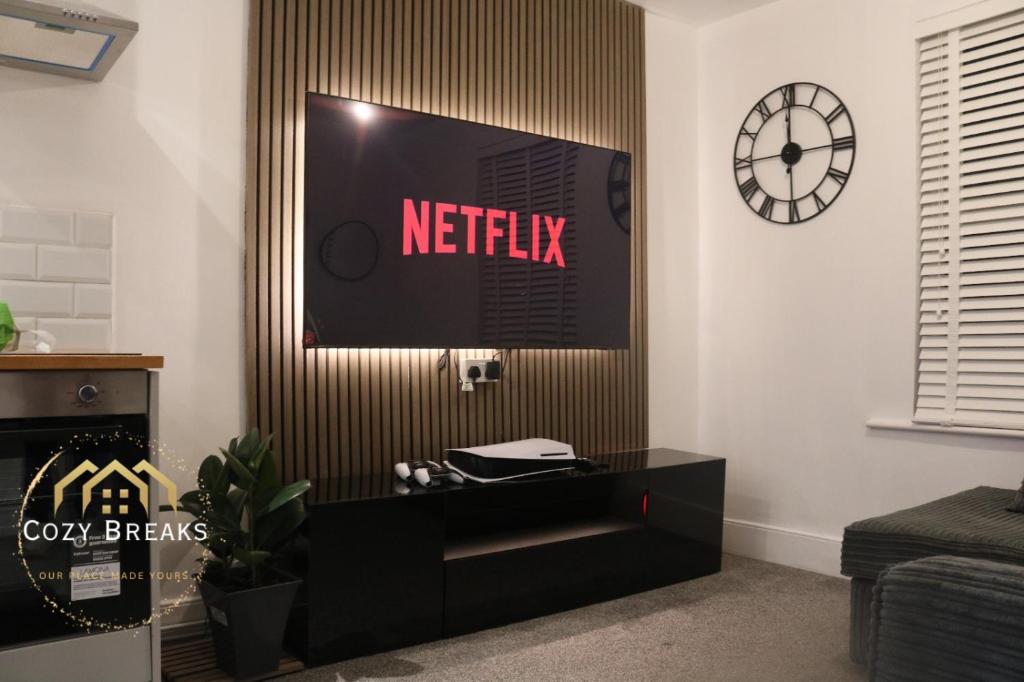 a living room with a netflix sign on the wall at Modern 2 bed flat Southampton- Close to Central Station & Shops in Southampton