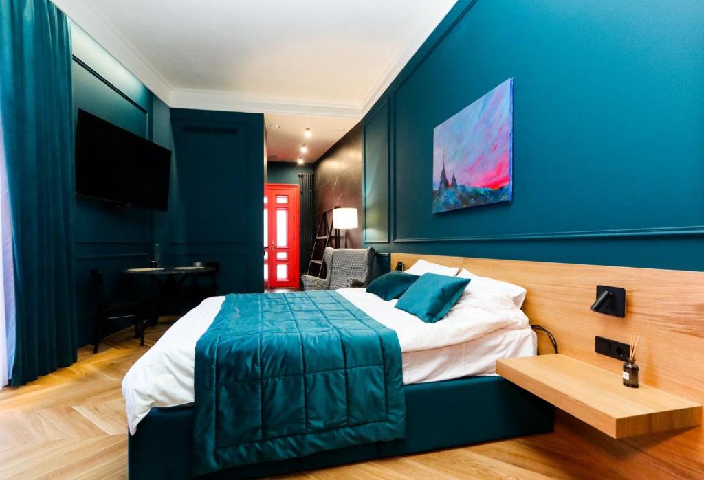 a bedroom with a blue wall with a bed and a desk at Once apartments in Ivano-Frankivsʼk