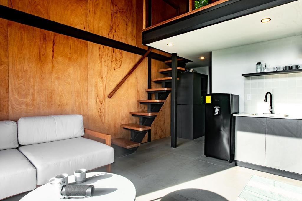 un soggiorno con divano e cucina di Tiny Home Samambaia - Sea view and bathtub a Alto del Espino Prieto