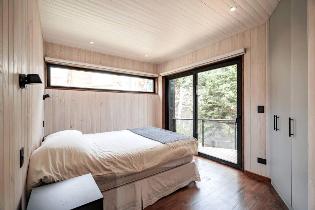 ein Schlafzimmer mit einem Bett und einem großen Fenster in der Unterkunft Punta Lobos Beachfront House, Taivarua in Pichilemu