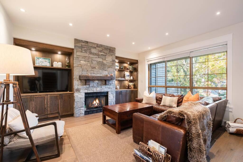 a living room with a couch and a fireplace at Englewoods Greens by Outpost Whistler in Whistler