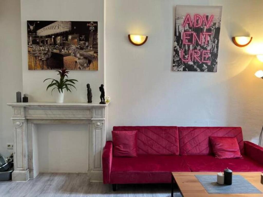 - un salon avec un canapé rouge et une cheminée dans l'établissement Flat Chatelain, à Bruxelles