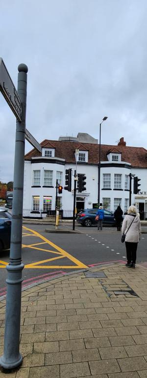 a woman walking down a street with a street sign at Ensuit Room in Solihull Town Centre in Solihull