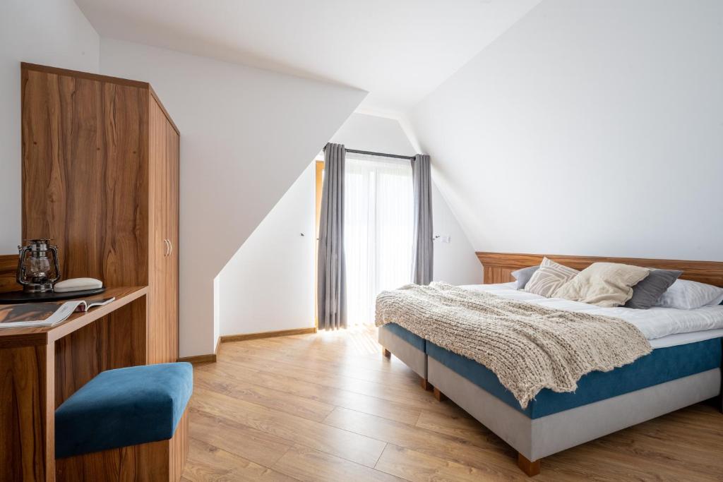 a bedroom with a bed with a blue chair at Para Apartments in Biały Dunajec