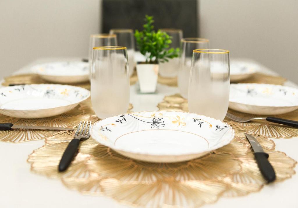 a table with plates and forks and glasses on it at Apto Adilson in Foz do Iguaçu